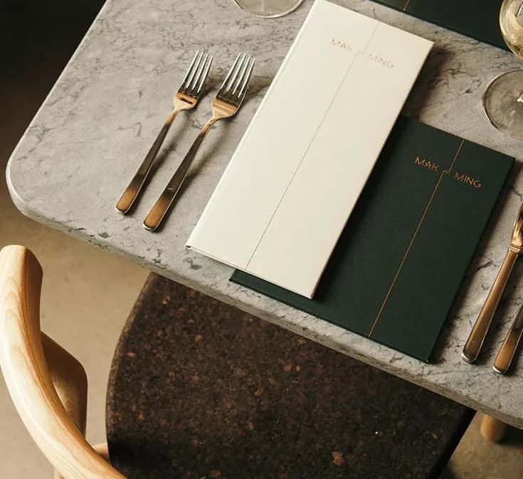 A restaurant table set with cutlery and menus