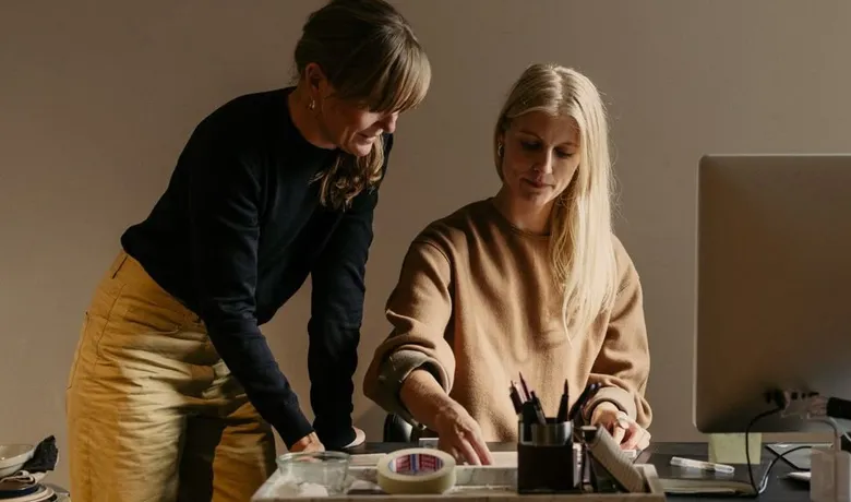 Two colleagues going through paperwork together at a desk